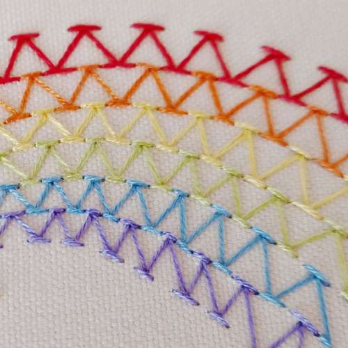File di punti chevron ricamati con fili dei colori dell'arcobaleno