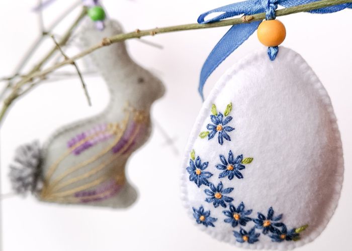 Uovo di Pasqua e coniglietto in feltro decorati su un ramo