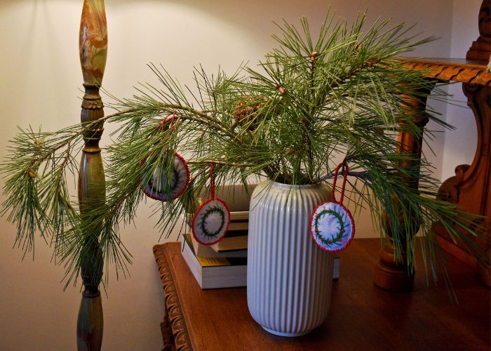 Ramo di pino in un vaso decorato con ornamenti fatti a mano