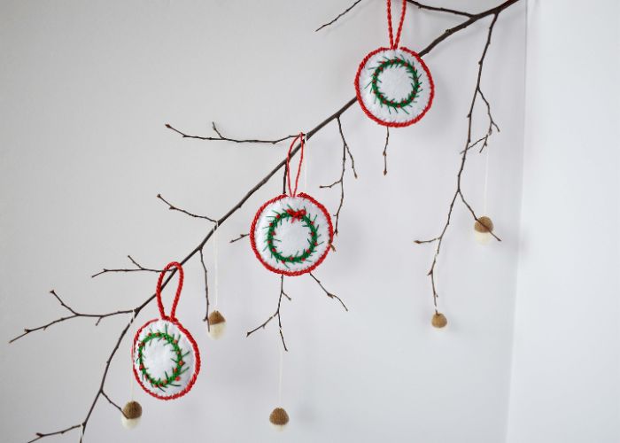 Ramo dell'albero decorato con ornamenti e ghiande fai da te