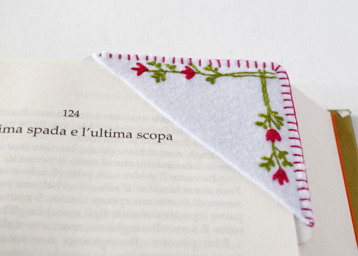 Segnalibro angolare ricamato a mano con fiori minimalisti su un libro